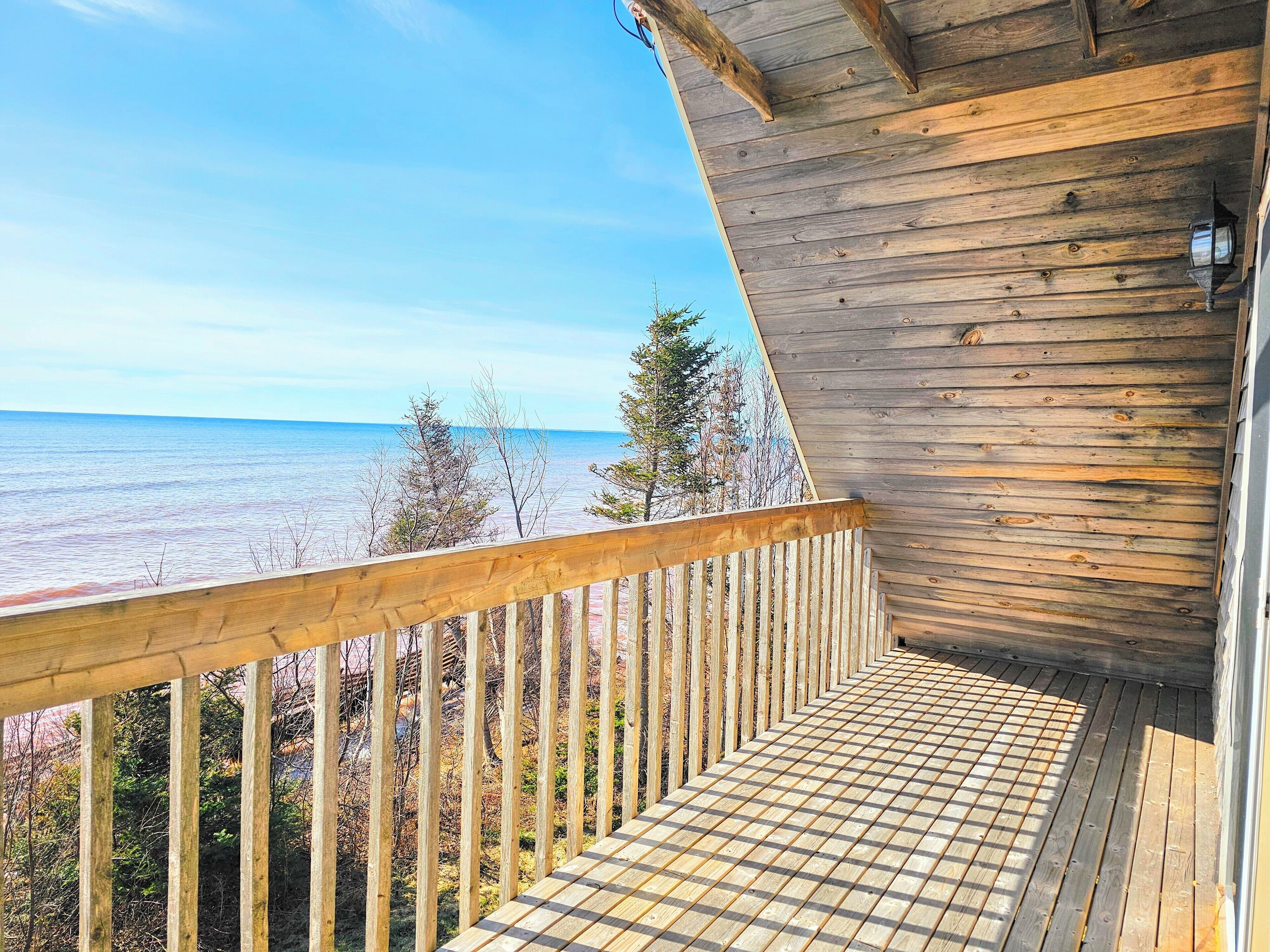 Une terrasse en bois avec vue sur l’océan.