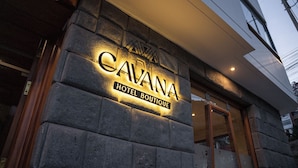 A stone facade with the sign "CAVANA HOTEL BOUTIQUE" illuminated. - Cavana Hotel Boutique Cusco (Cusco)