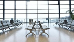 A spacious airport terminal with rows of modern, metal-framed chairs and a large windowed wall providing a view of the sky. - Hanting Hotel Shanghai Hongqiao Airport Beidi Road (Shanghai)