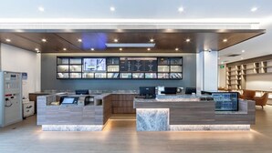 A modern reception desk with a marble counter, a digital display, and a wall-mounted information board. - Hanting Hotel Shanghai Hongqiao Airport Beidi Road (Shanghai)