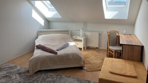 A bedroom with a bed, a desk, a chair, and skylights. - Cozy family apartment in the heart of Görlitz, also suitable for fitters (Görlitz)