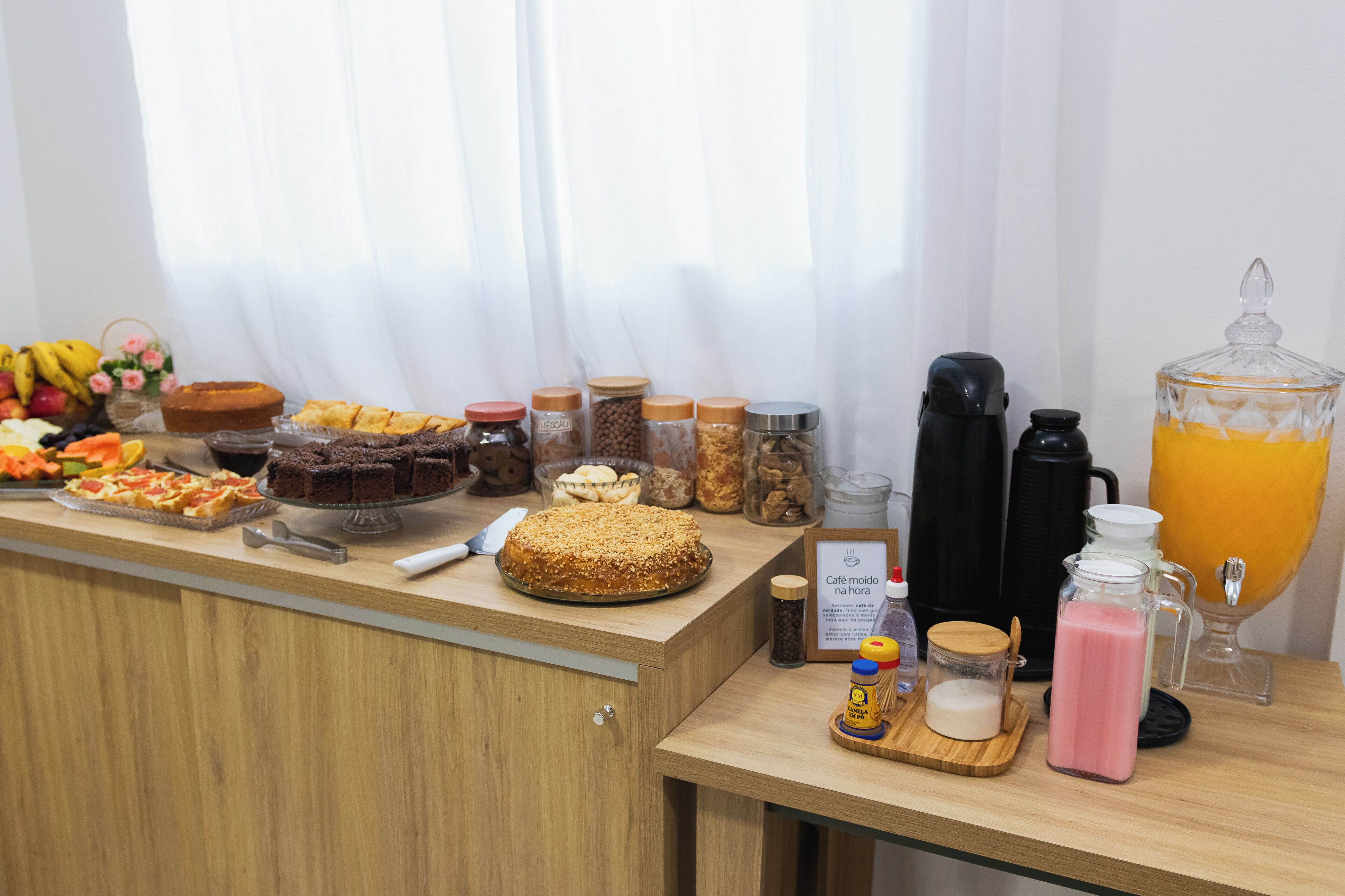 A breakfast buffet with various food items, including fruits, pastries, and beverages.