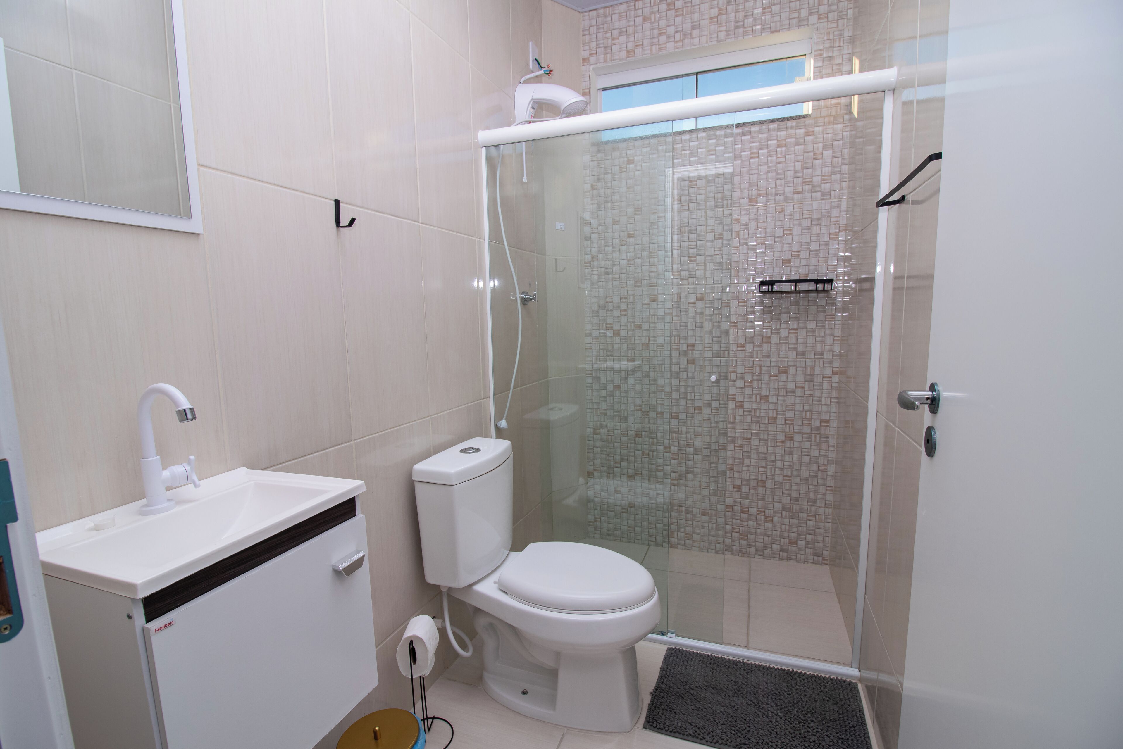 A modern bathroom with a toilet, sink, and glass-enclosed shower.