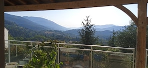 Een balkon met uitzicht op een bergachtig landschap.