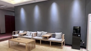 Un interior moderno con un conjunto de sofá, una mesa de centro de madera y un mueble negro.