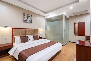 A hotel room with a large bed, a glass shower enclosure, and a wooden nightstand. - GeLinHaoTai BeiKe Business Hotel (Yucheng)
