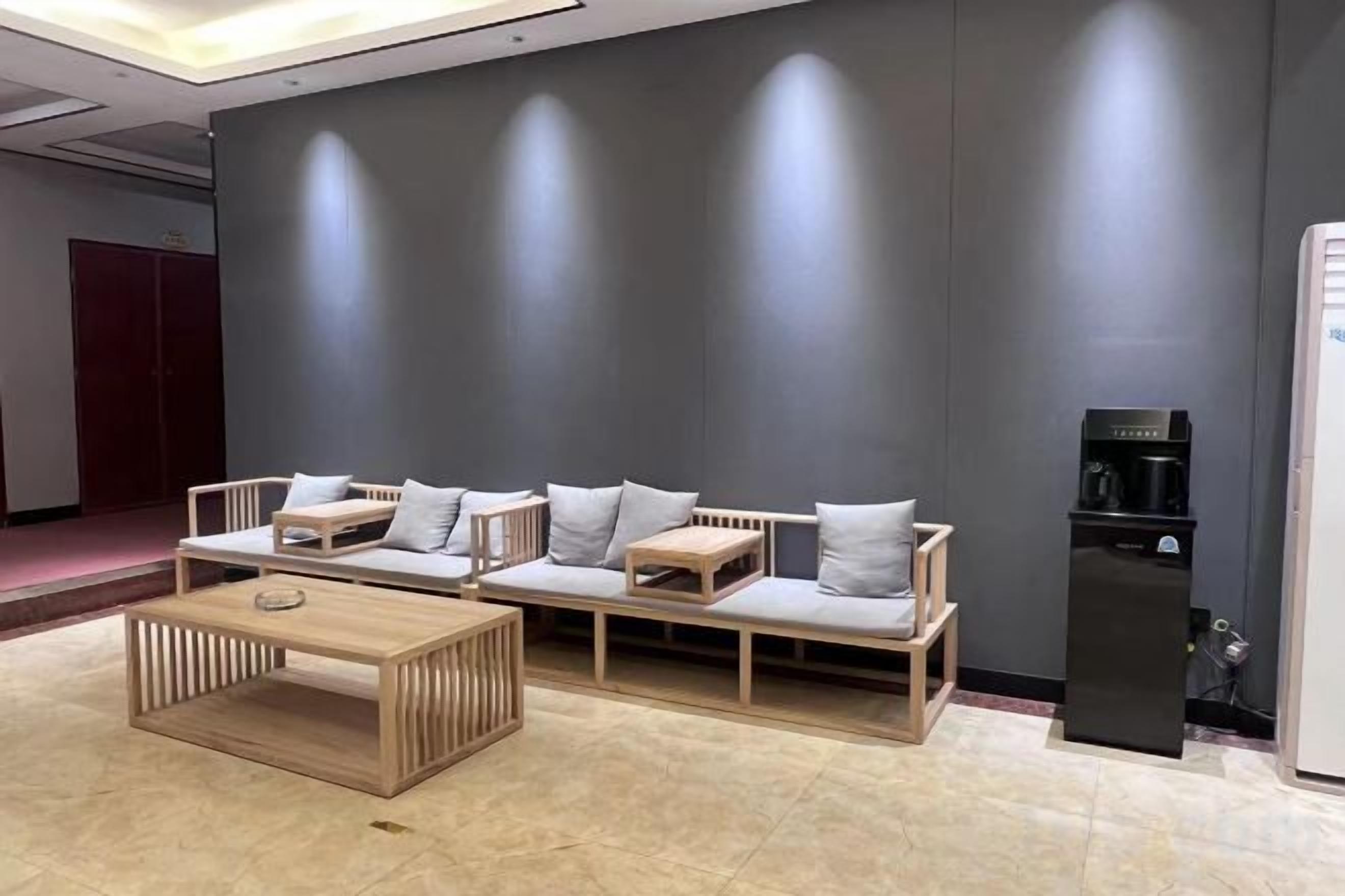 A modern lounge area with a sofa set, a coffee table, and a water dispenser.