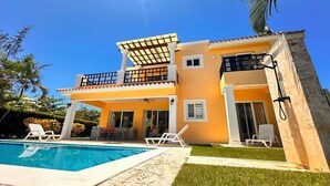 A two-story house with a swimming pool, outdoor seating, and a balcony. - Villa Giallo | Private Pool | Sosúa Ocean Village (Sosúa)