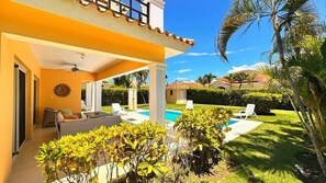 A covered outdoor area with a pool, lounge chairs, and a patio with a ceiling fan. - Villa Giallo | Private Pool | Sosúa Ocean Village (Sosúa)