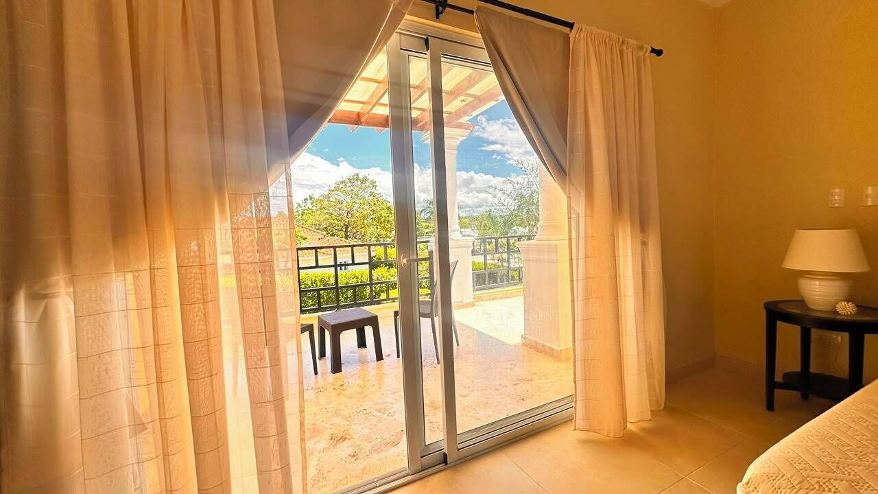 A room with a sliding glass door leading to an outdoor patio with a table and chairs.