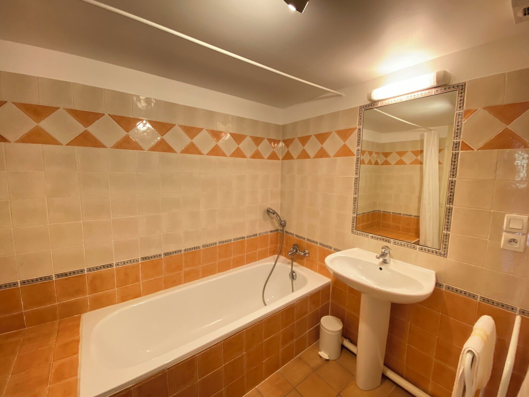 Une salle de bain avec une baignoire, un lavabo et un miroir.
