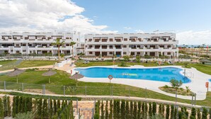 A modern hotel with a large swimming pool, multiple balconies, and a well-maintained garden area. - Apartamento Vamos (Mar de Pulpi) (San Juan de los terreros)