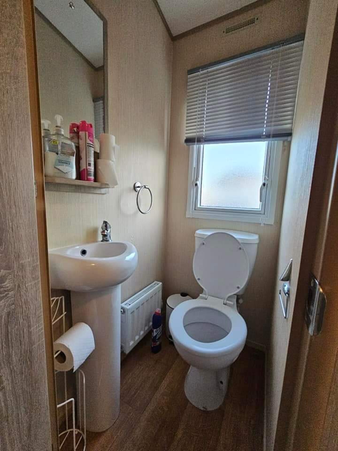 Ein kleines Badezimmer mit Waschbecken, Toilette und Fenster.