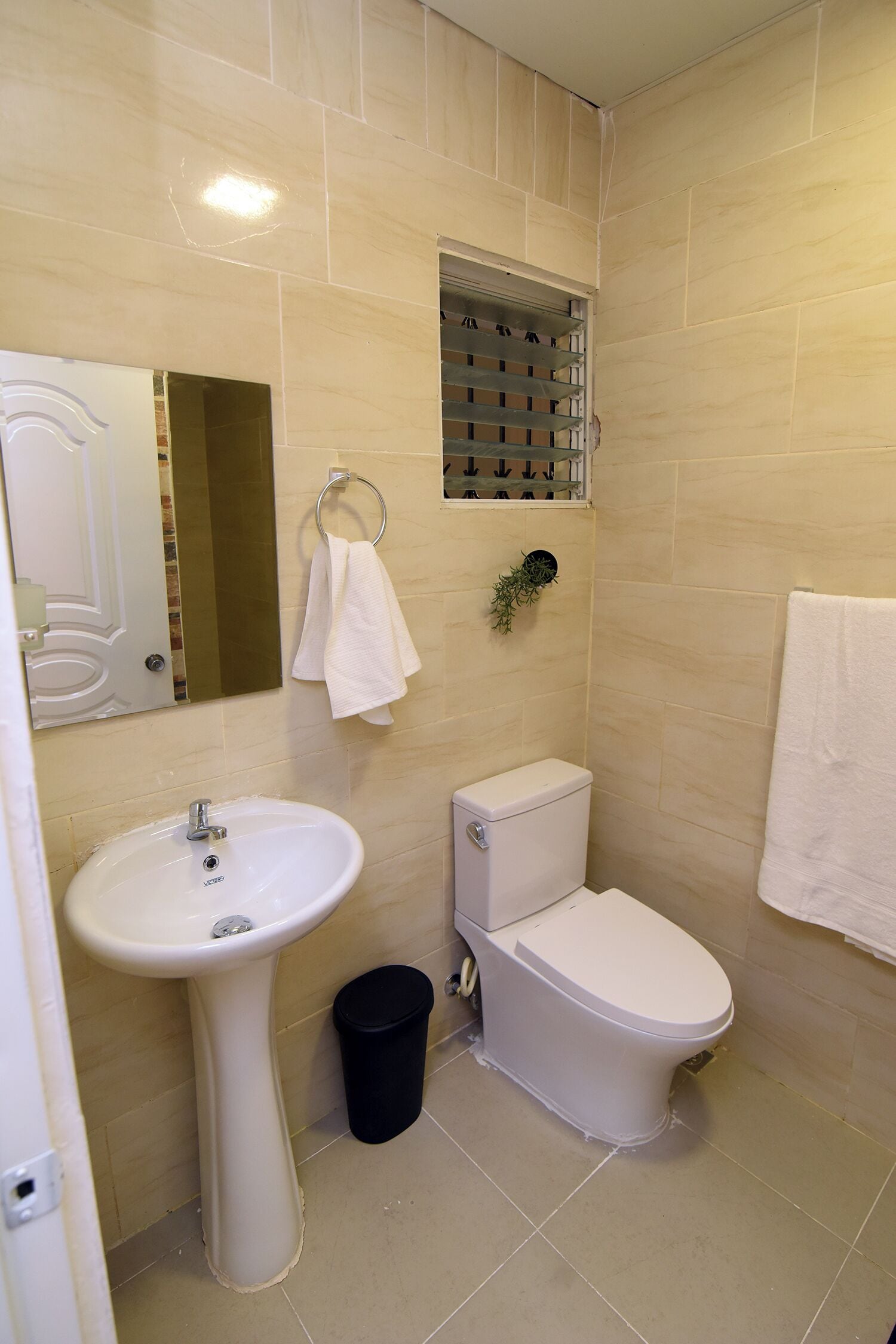 Een badkamer met een wastafel, toilet en een handdoekhouder.
