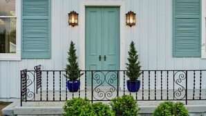 A house with a teal door, two lanterns, and potted plants. - Historic Estate-Slps 16-Downtown-Soak Pool-Hot Tub (Murfreesboro)