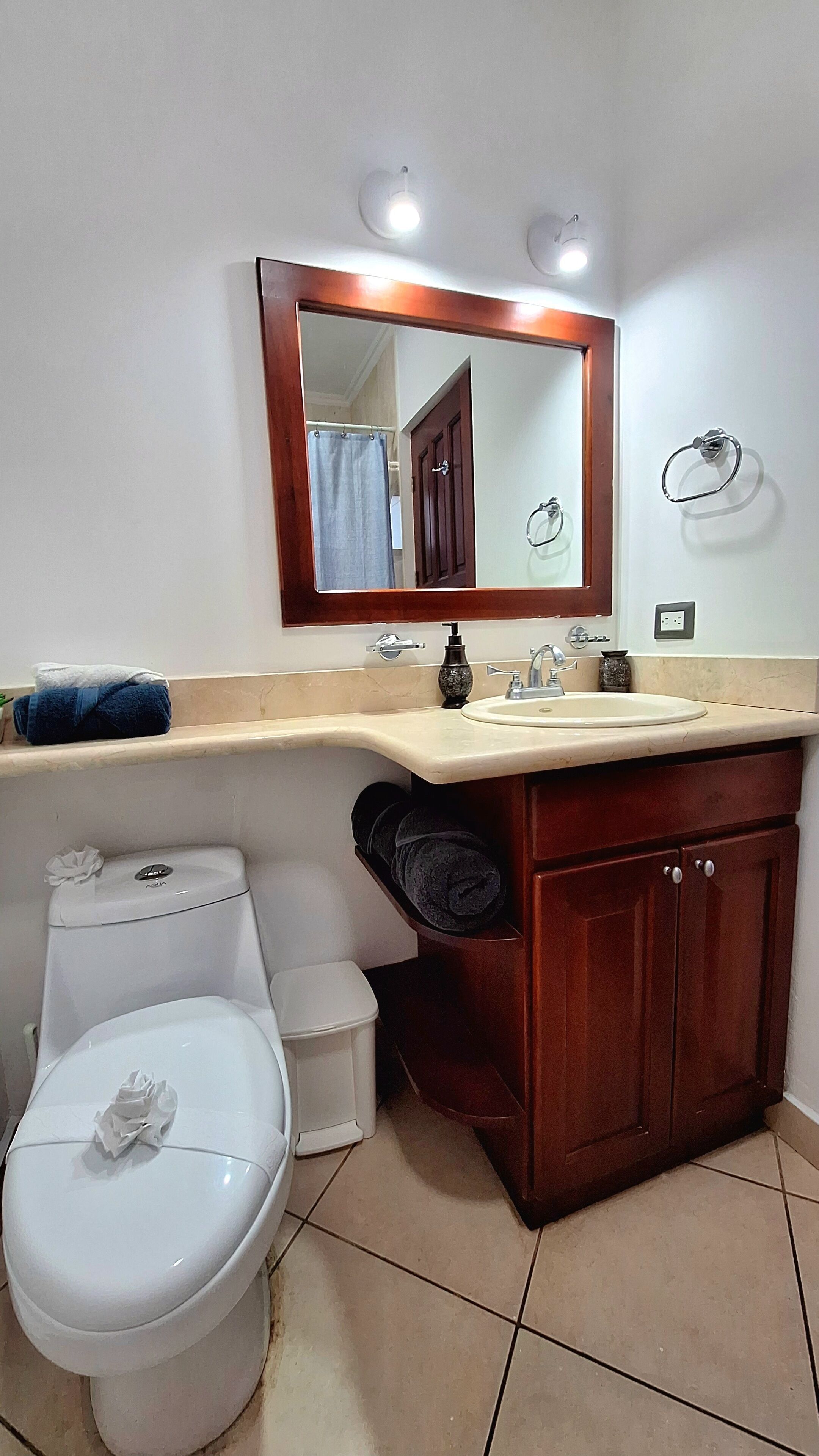 Ein Badezimmer mit Toilette, Waschbecken und Spiegel.
