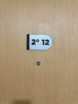 A wooden door with a metal sign indicating room number 2° 12. - Choconcito Suite (Ushuaia)