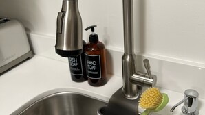 A stainless steel kitchen sink with a modern faucet, two soap bottles, and a dish brush. - Super Convenient, Cozy 2B1b Apartment, Berkeley (Berkeley)