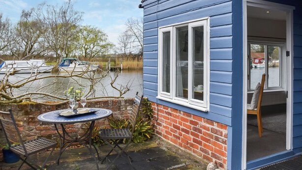 A blue house with a brick foundation, a window, and a door. - 1 bedroom accommodation in Beccles (Beccles)