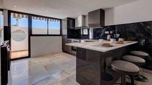 A modern kitchen with a large island, dark marble backsplash, and a view of the outdoors. - Three Bedroom Townhouse 100 meters from the Beach! (Playa del Sol Villacana)
