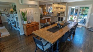 A spacious kitchen with a large island, modern appliances, and a view to the backyard. - Couple's Oasis at Horner Park, Welch Homes & Hospitality, pet friendly property. (Saanich)