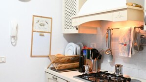 A kitchen with a gas stove, a sink, a dish rack, and a clock on the wall. - S346 – Sirolo, three-room apartment in a residential area (Sirolo)