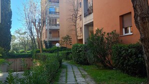A pathway leading to a residential building with balconies and a garden area. - SE154 – Senigallia, large four-room apartment convenient to services (Senigallia)