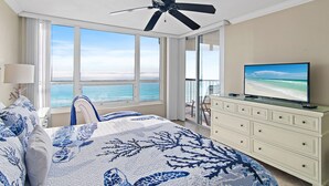A bedroom with a bed, a television, a ceiling fan, and a view of the ocean. - Perfect Getaway - Amazing Views Beach Front 2 Beds 2 Baths Hidden Dunes (Miramar Beach)