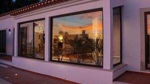 Un edificio moderno con grandes ventanales que reflejan el atardecer.