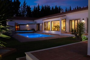 A modern house with a swimming pool, large windows, and a well-lit patio area. - Santar m Private Pool Sauna Gym Villa (Santarém)