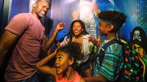 A group of people in an elevator with a space-themed mural on the wall. - LEGOLAND California Hotel (Carlsbad)