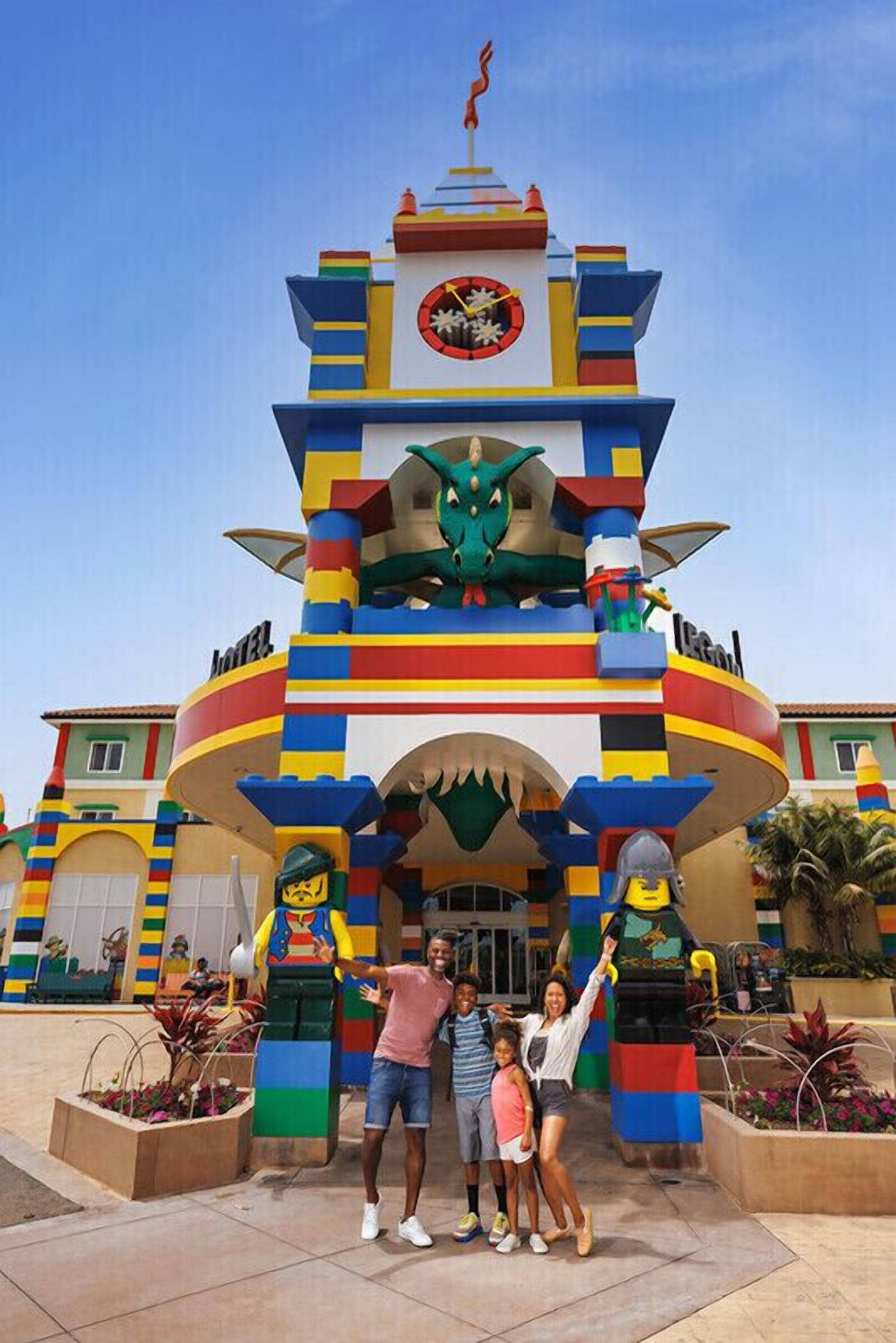 Un edificio colorido con un reloj, un dragón y una estatua de un personaje.