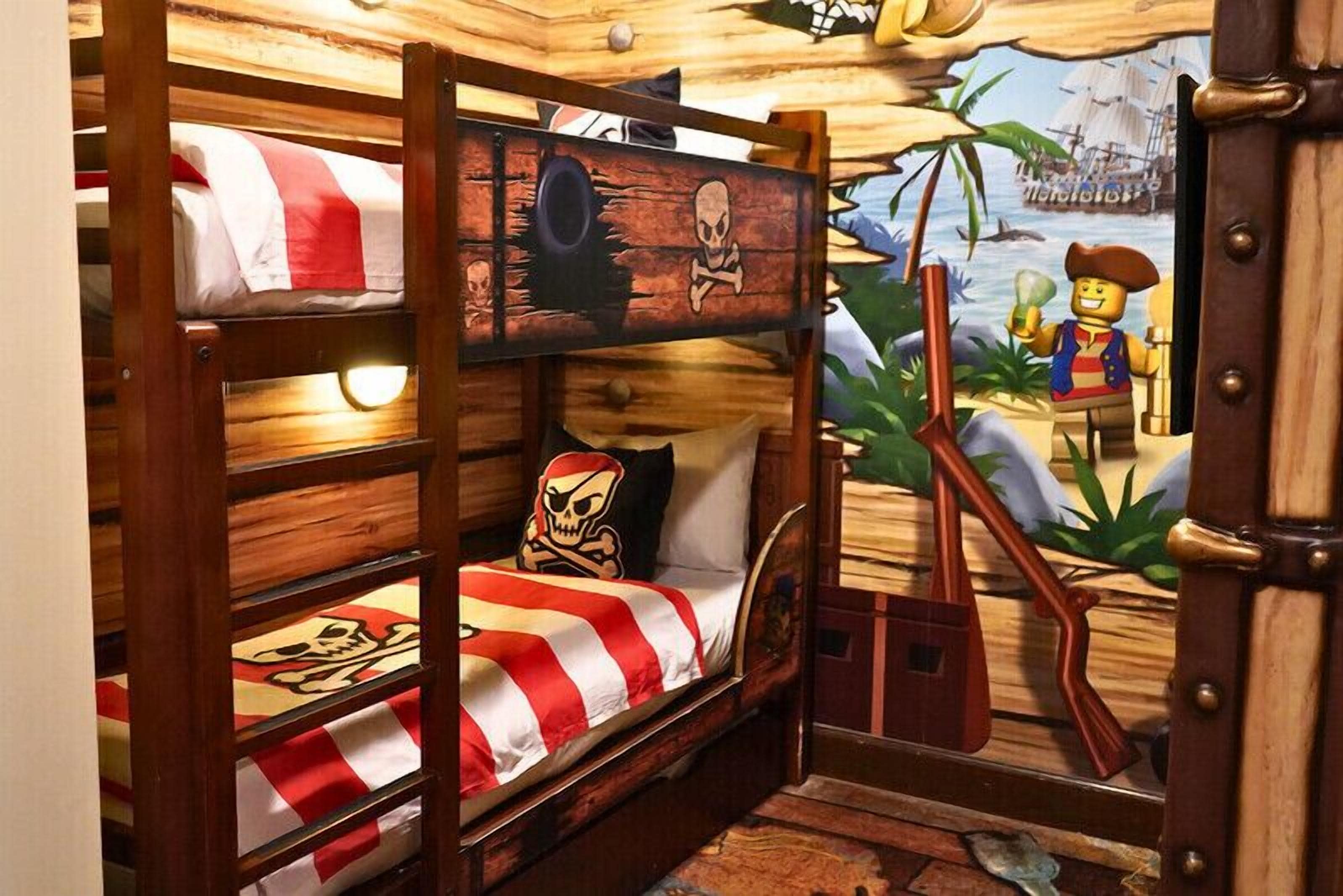 A bunk bed room with a pirate-themed mural and a small table with a toy pirate.