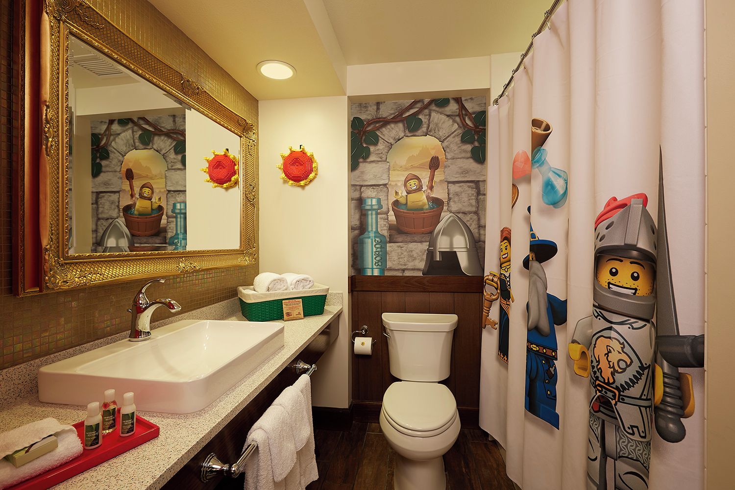 A bathroom with a large mirror, a sink, a toilet, and a shower curtain with a cartoon character design.