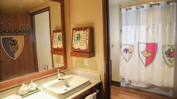 Un baño con lavamanos, espejo y dos frases motivacionales enmarcadas.