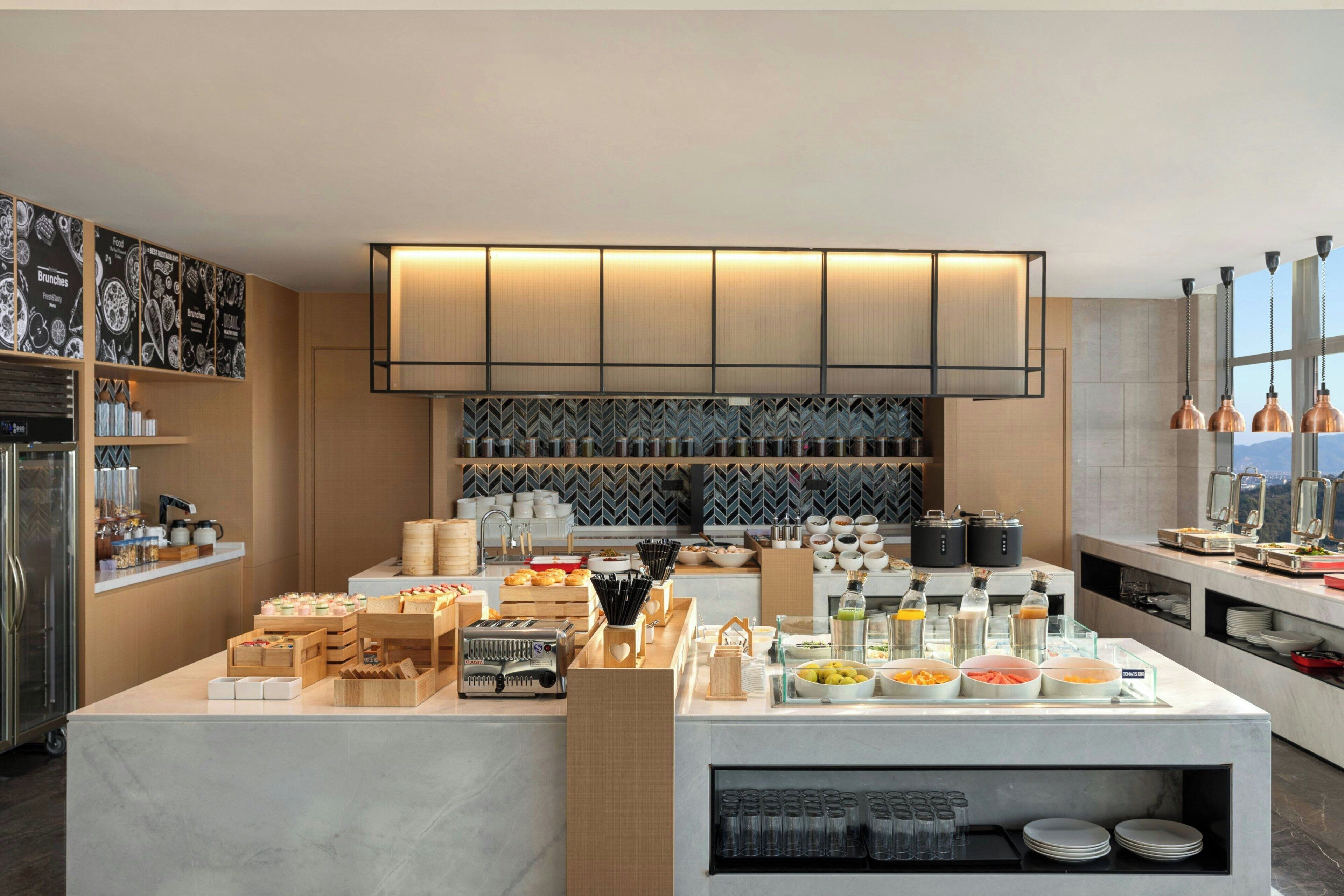 Een moderne keuken met een buffetopstelling, inclusief diverse gerechten en bestek.