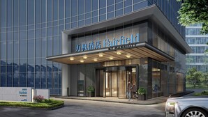 A modern hotel entrance with glass doors and a sign reading "Fairfield by Marriott."