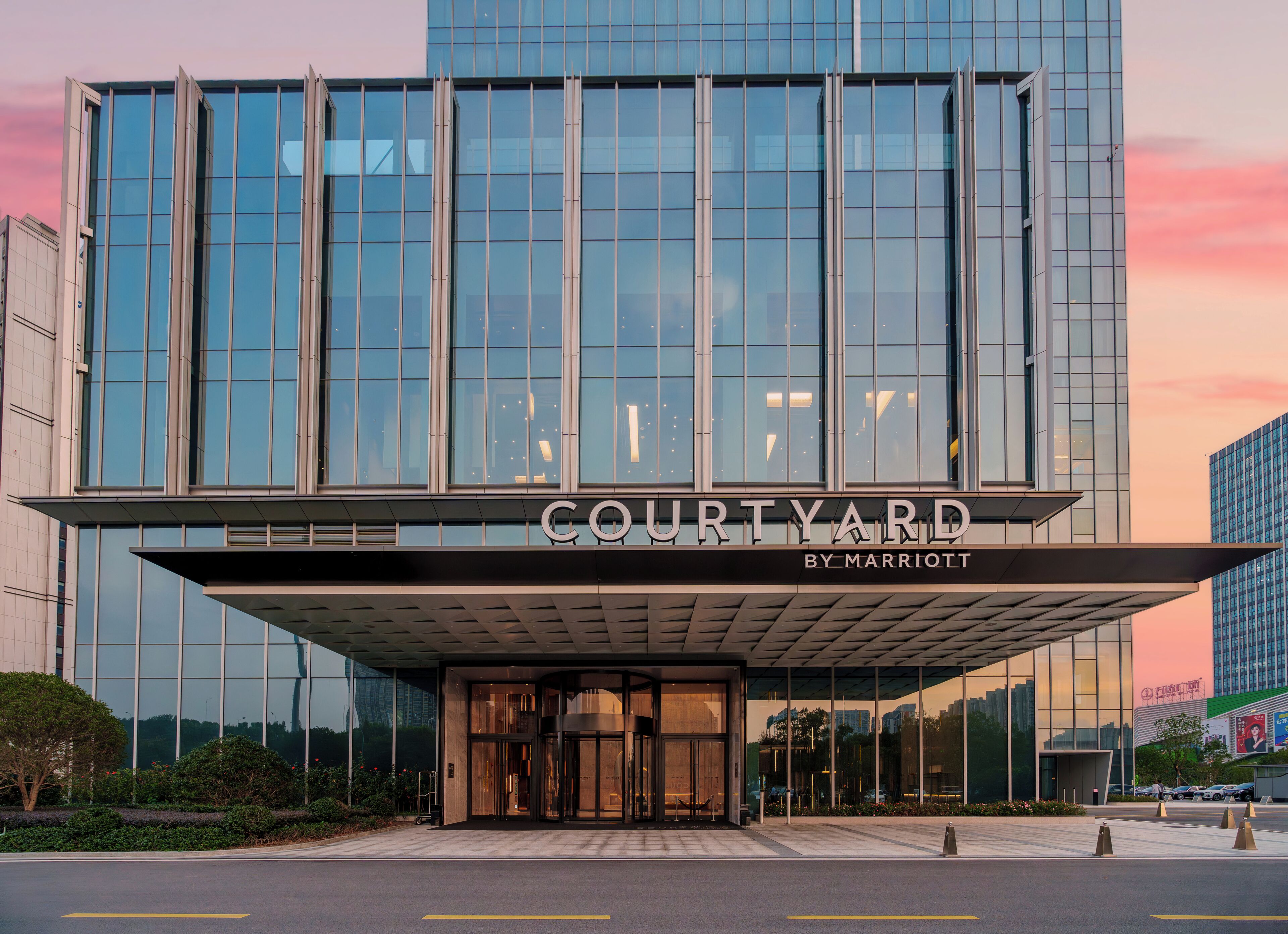 Ein moderner Hotelzugang mit Glasfassade und einem Schild mit der Aufschrift "COURTYARD BY MARRIOTT".