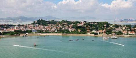 A coastal cityscape with a marina, boats, and a hilly backdrop.