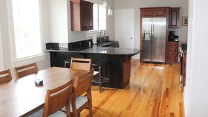 Una cocina moderna con armarios de madera, un refrigerador de acero inoxidable y una isla grande con asientos.