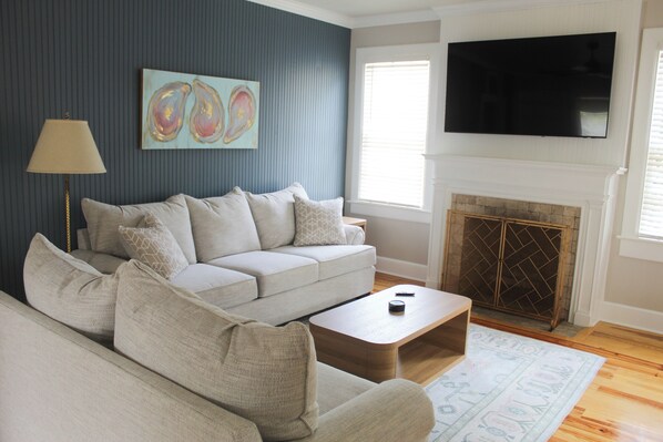 A living room with a sofa, coffee table, and fireplace. - Welcome to The Shrimp Shack! (Gulfport)