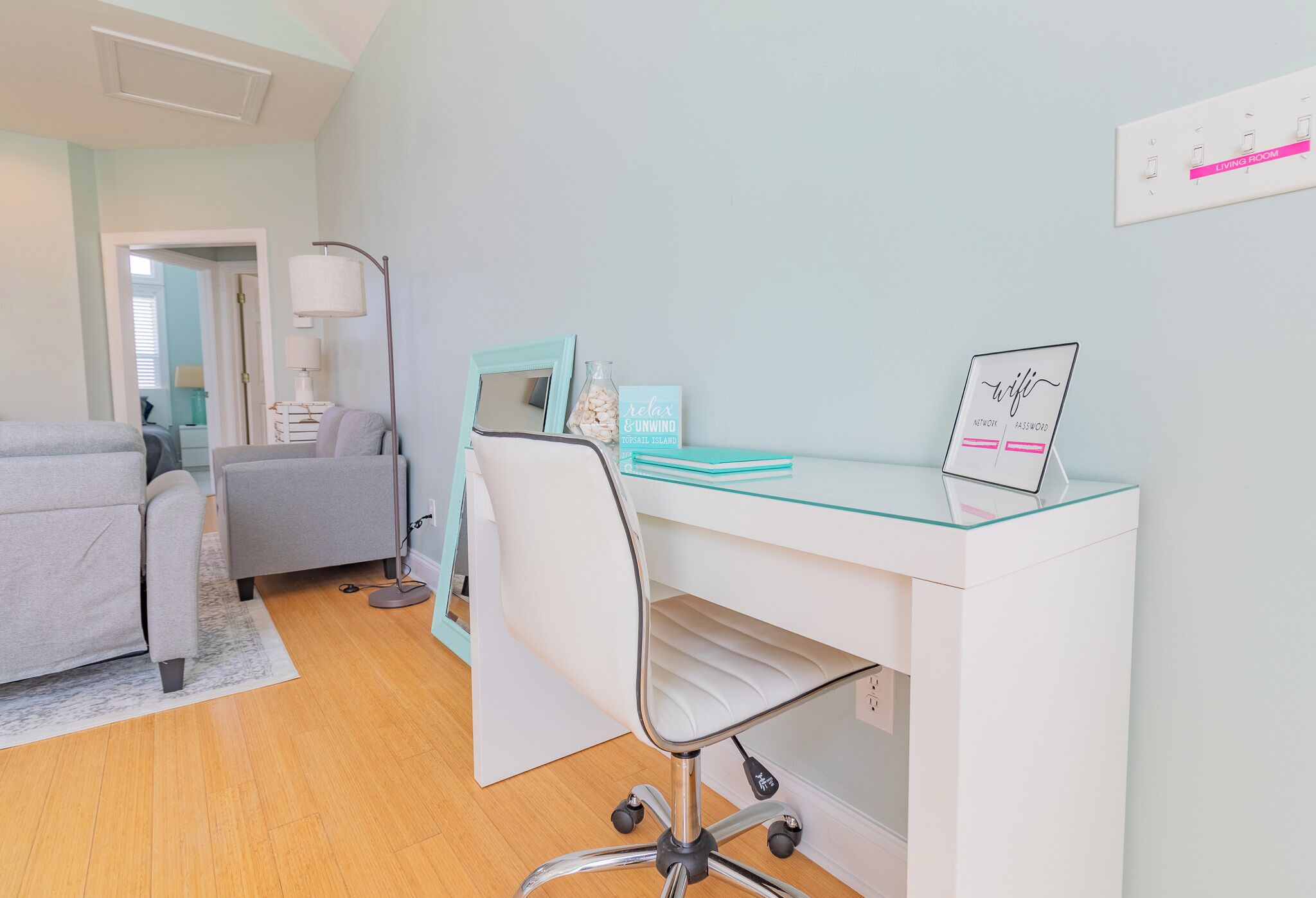Une chambre à coucher moderne avec un lit, un bureau et une chaise, une lampe et une table de chevet.