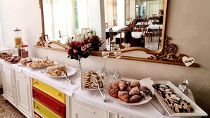 A buffet setup with various food items and a mirror above. - hotel Anny  (Cervia)