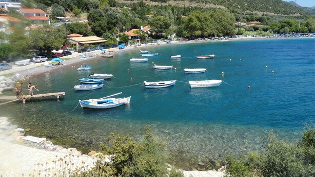 A coastal area with boats docked near the shore, a clear beach, and a mountainous backdrop. - Lahtagas Estate with private swimming pool (Loutraki)