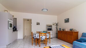 Un espace de vie compact comprenant un coin repas, une kitchenette et un canapé.
