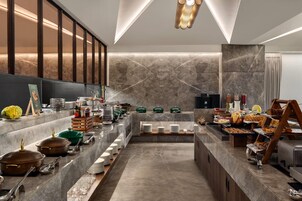 A modern buffet setup with various food items and utensils.