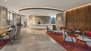 A modern lobby with a reception desk, seating area, and a large window providing natural light. - Ramada Encore By Wyndham Ambala Gt Road (Ambala)