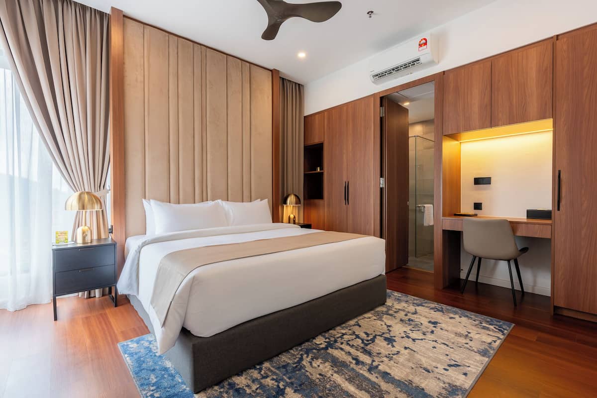 Una habitación de hotel moderna con una cama grande, un escritorio y un vestidor.