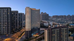 A high-rise hotel with multiple floors, a prominent entrance, and a well-lit facade. - Ramada Plaza By Wyndham Wuhan Dongxi Lake (Wuhan)