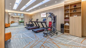 A modern gym with treadmills, a weight machine, and a yoga mat area. - Ramada Plaza By Wyndham Wuhan Dongxi Lake (Wuhan)